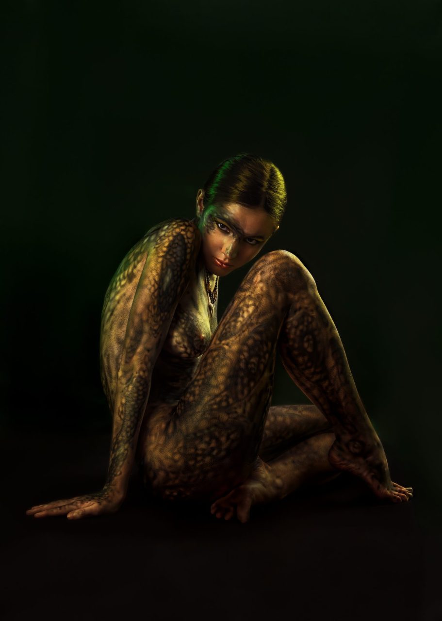Modèle nu posant dans un studio lumineux pour une séance de photographie artistique.